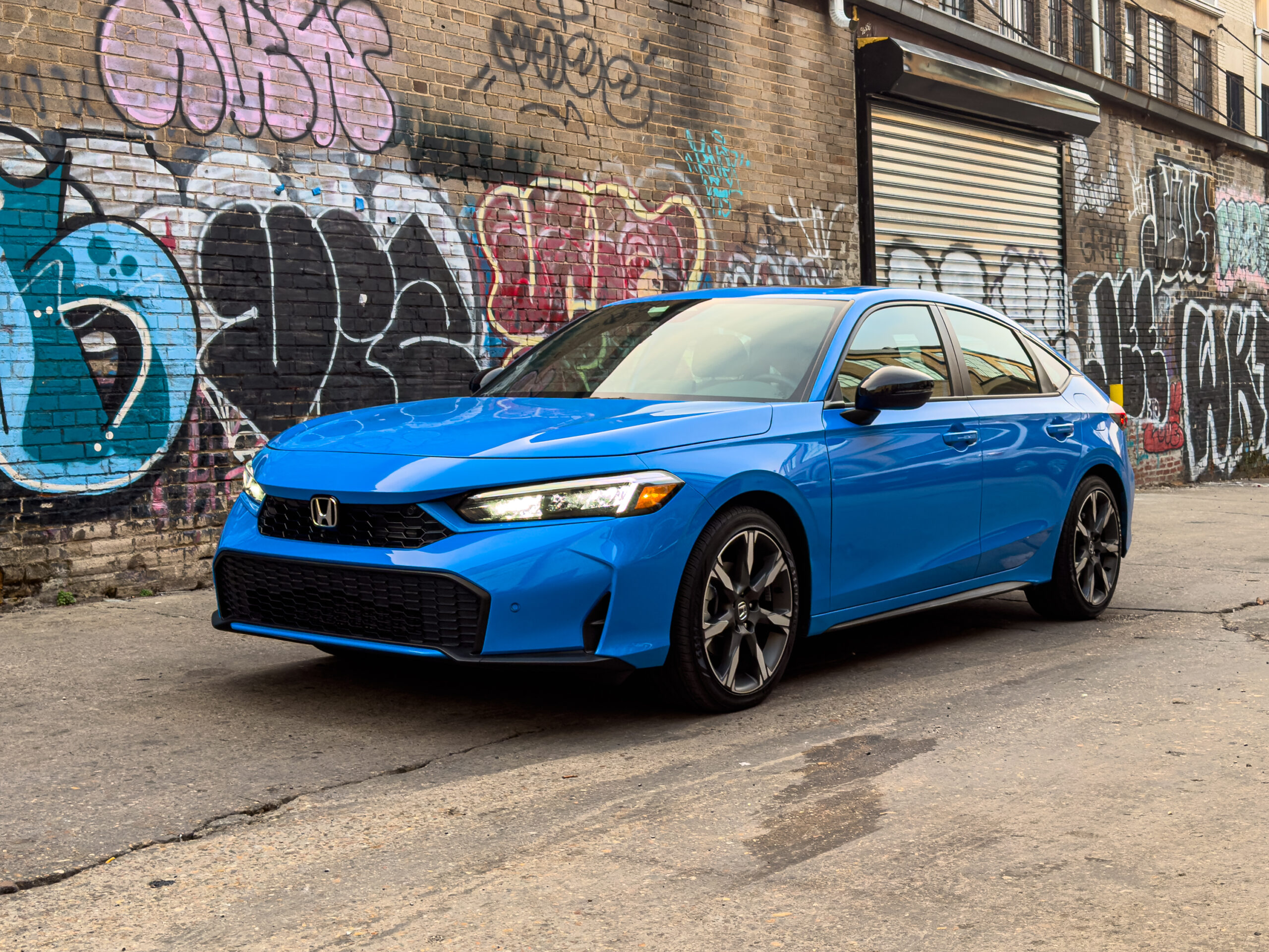A blue Honda Civic parked in an alley