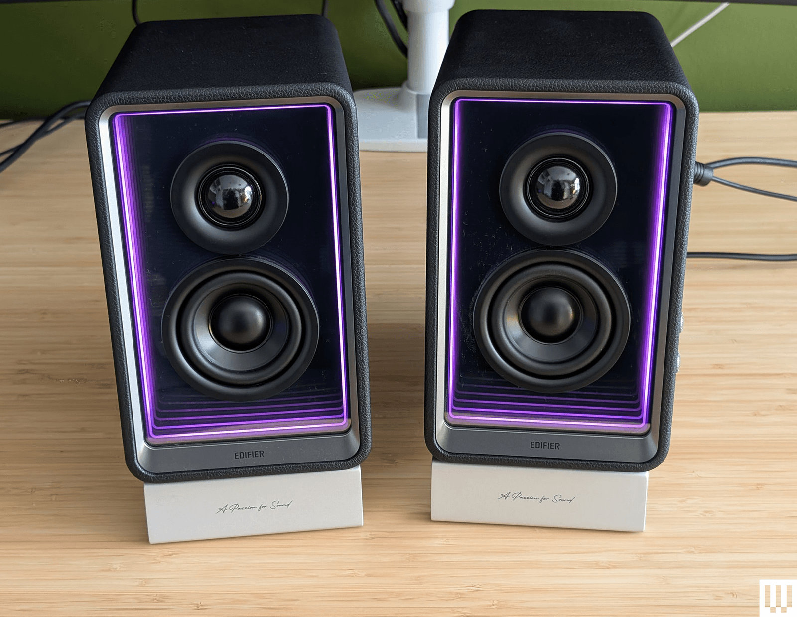 Edifier QR65 black rectangular speakers with purple interior trim sitting on a wooden desk