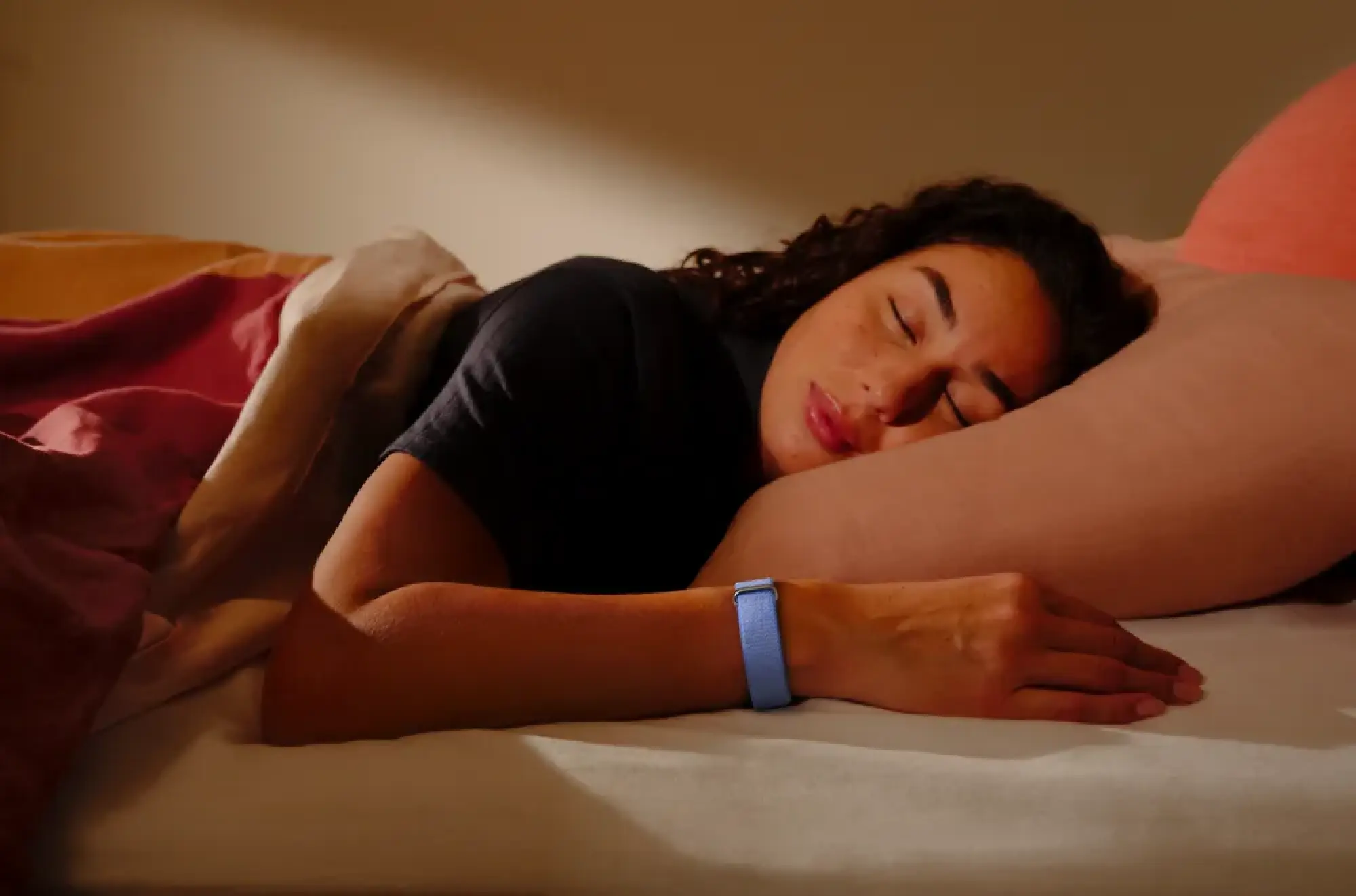 Woman sleeping with Fitbit Air on