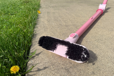 Shark BlastBoss with broom attachment on sidewalk near grass