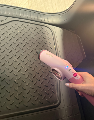Leah using Shark BlastBoss to blow debris out of car trunk