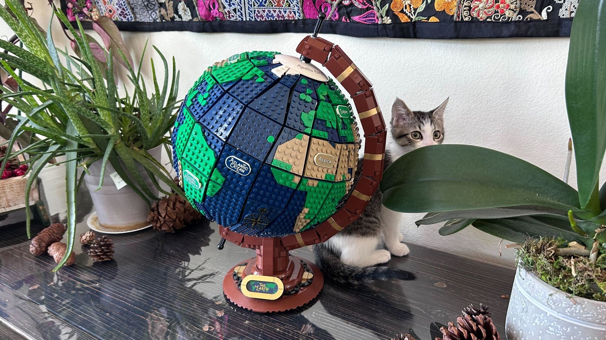 lego globe on sideboard next to plants and kitten