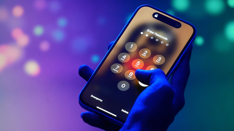 Someone entering a passcode on an iPhone lockscreen