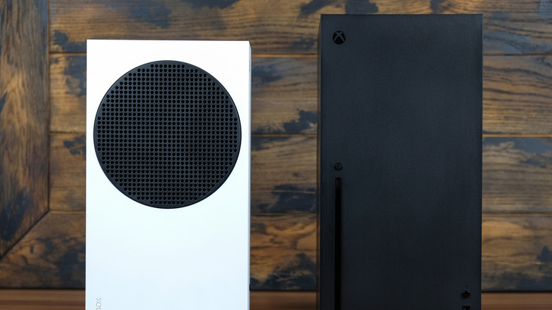 A white Xbox Series S sitting next to a black Xbox Series X.