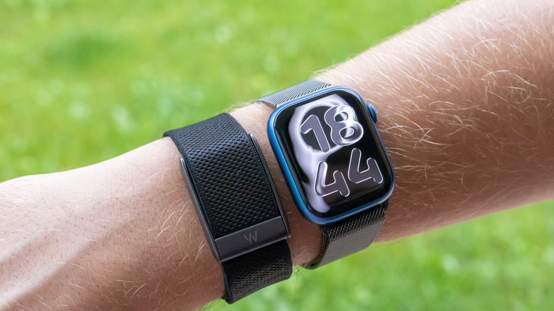 A Whoop alongside an Apple Watch, both on-wrist.
